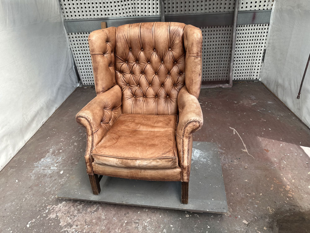 another leather wingback chair before restoration